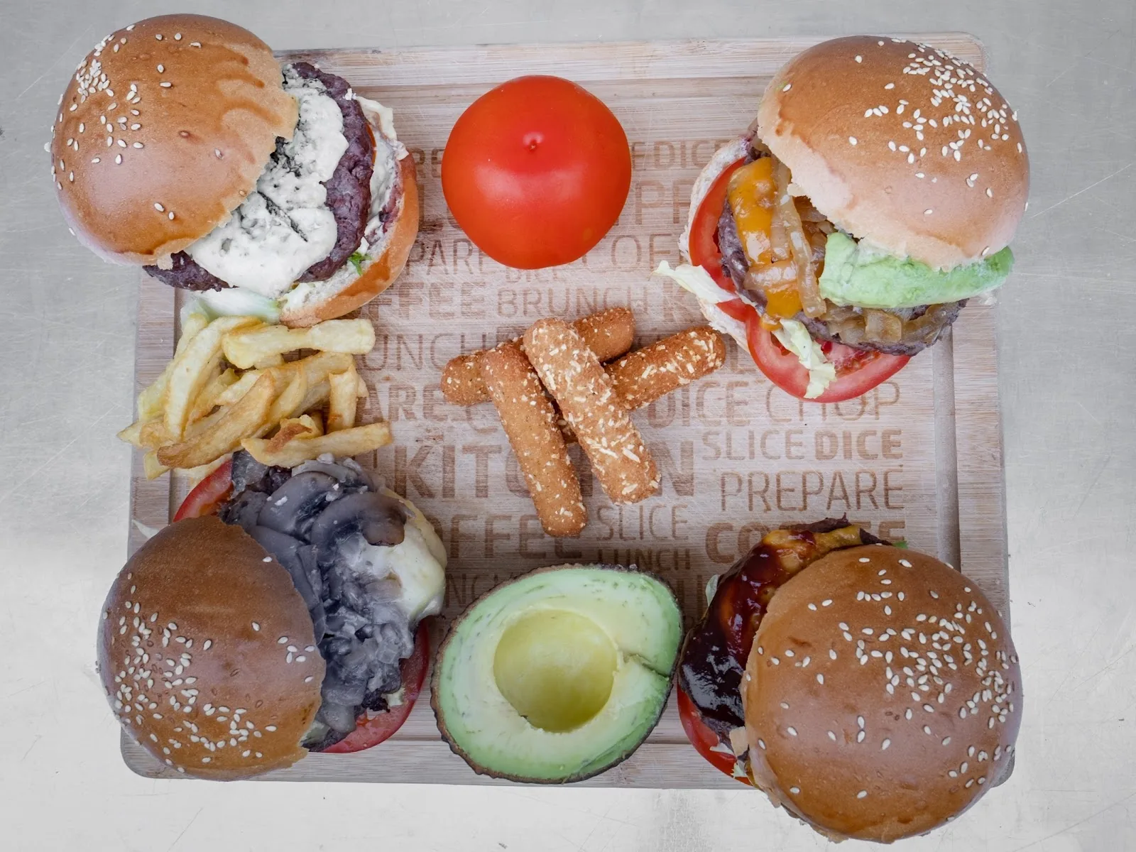 Les quatre burgers, frites et bâtonnets de mozzarella sur la planche du camion